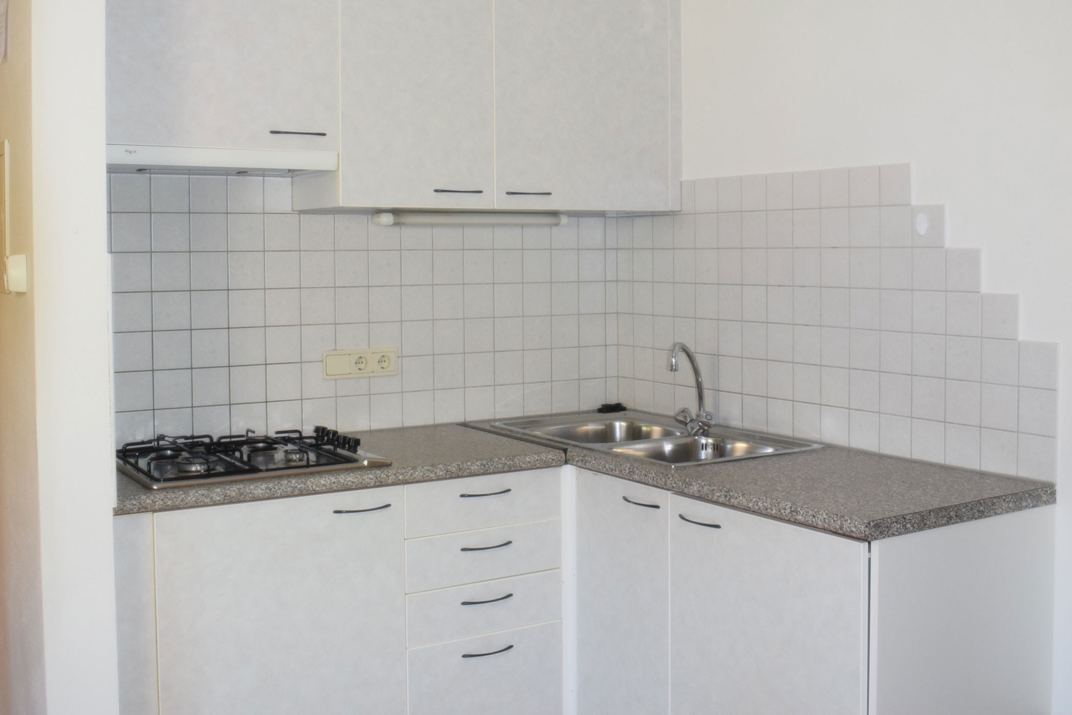 Una cucina con lavello e fornelli.