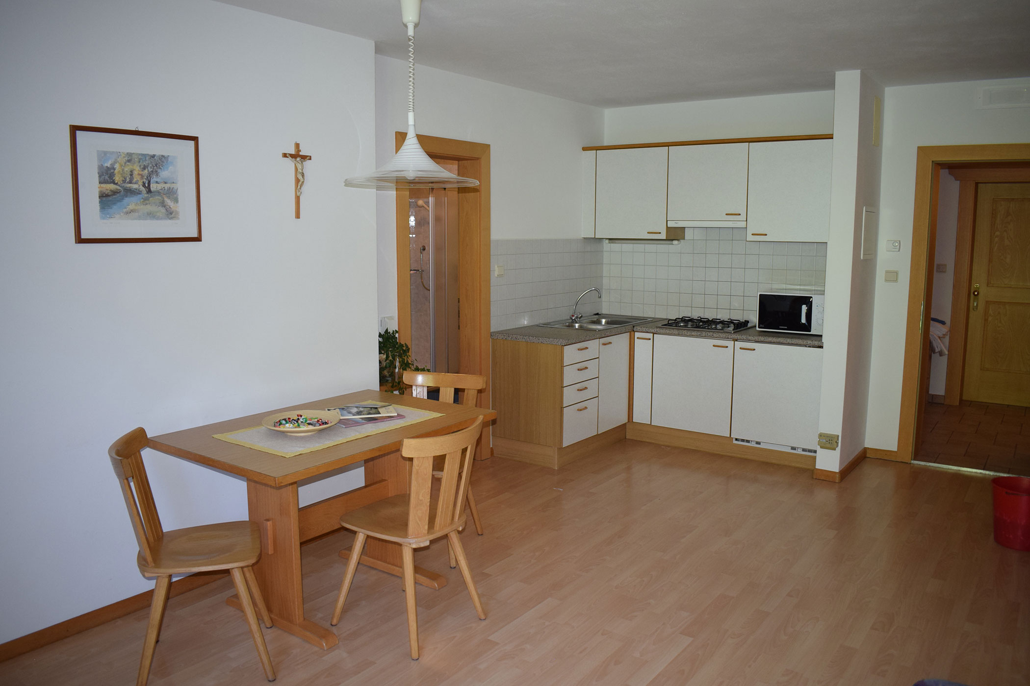 Una cucina con un tavolo, 3 sedie e un lavello.