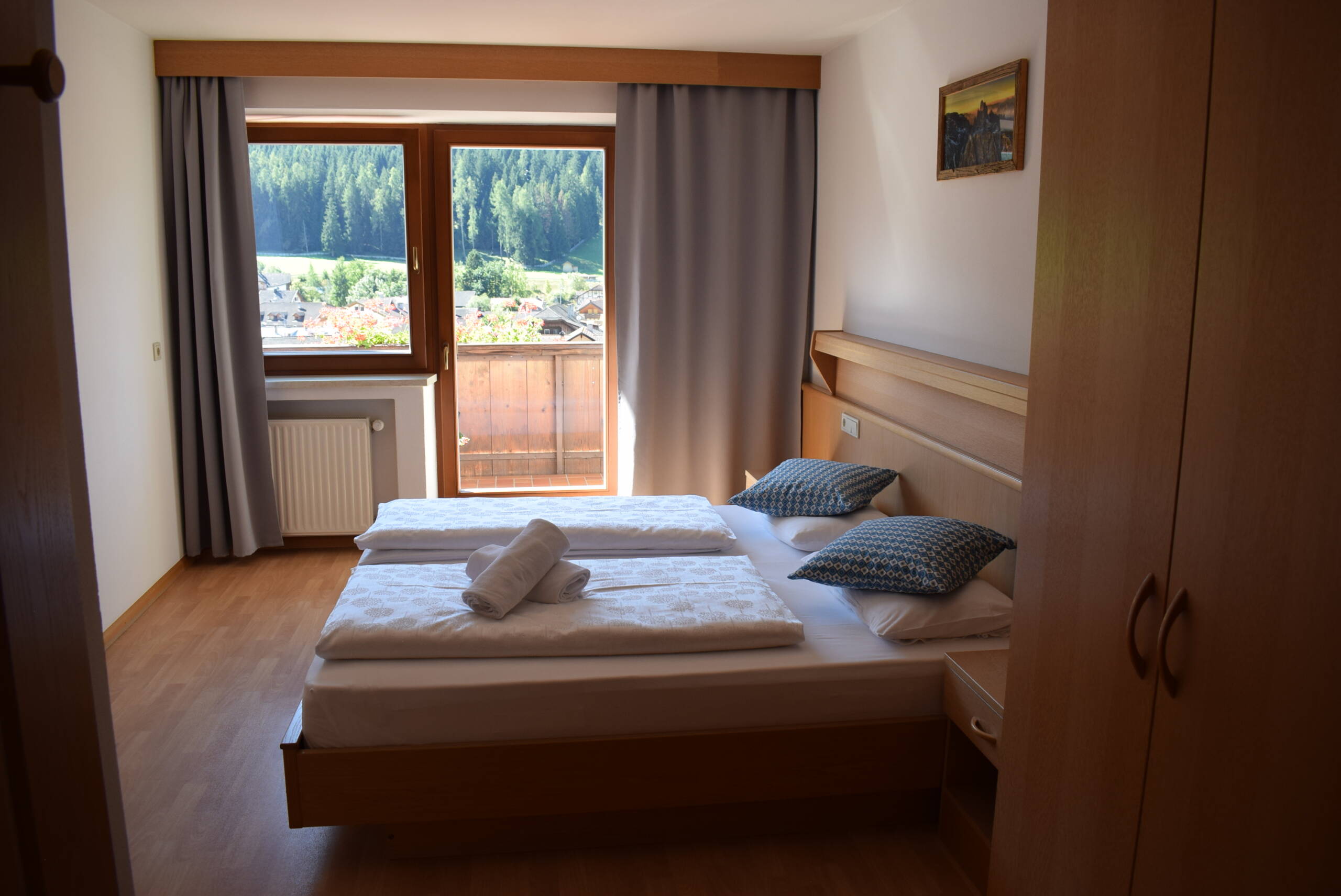 Una camera da letto con due letti e una finestra che lascia entrare la luce del giorno.